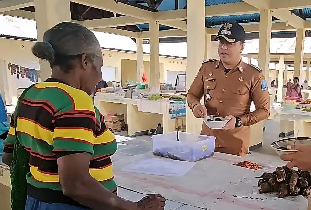 Kepala Distrik Nimboran, Ridwan Wijayanto, S.STP, MK sedang berdiskusi dengan salah satu pedagang di Pasar Banuku