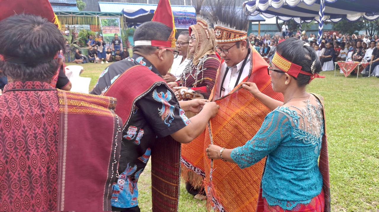 Staf Ahli Bidang Pemerintahan dan Hukum Setda Kabupaten Jayapura, H. Sakaruddin, S.Pd., M.M., Kepala Dinas Pendidikan Kabupaten Jayapura, Amelia Ondikeleuw, S.Pd., Kepala Sekolah SMP Negeri 2 Sentani, Murni, S.Pd., M.Pd., saat menerima Ulos dari Sumatera Utara, di Lapangan SMPN 2 Sentani. Rabu (29/04/2026)