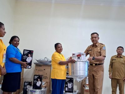 Asisten II Bidang Perekonomian dan Pembangunan Setda Kabupaten Jayapura, Dr. Abdul Rahman Basri, didampingi Kepala Dinas Koperasi dan UMKM Kabupaten Jayapura, Haryanto, saat menyerahkan bantuan kepada salah satu peserta UMKM di Hotel Yuda Sentani. (Selasa 07/07/2026)