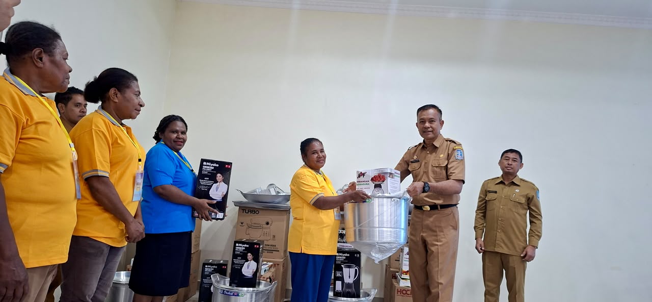 Asisten II Bidang Perekonomian dan Pembangunan Setda Kabupaten Jayapura, Dr. Abdul Rahman Basri, didampingi Kepala Dinas Koperasi dan UMKM Kabupaten Jayapura, Haryanto, saat menyerahkan bantuan kepada salah satu peserta UMKM di Hotel Yuda Sentani. (Selasa 07/07/2026)