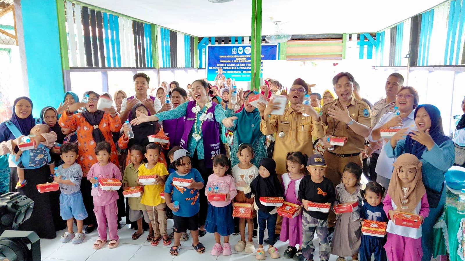 Ketua TP-PKK Kabupaten Jayapura, Ny. Dewi Sartika S. Wonda, S.Par., bersama Tim Pembina Posyandu 6 SPM dan jajaran pemerintah berfoto bersama anak-anak usai serah terima hasil renovasi Posyandu di Nimbokrang. Senin (6/7/2026)